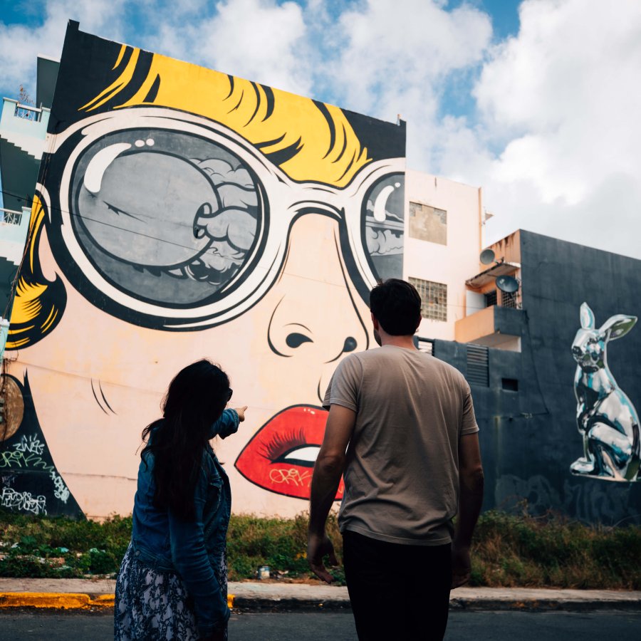 Two people admire the murals in Santurce.