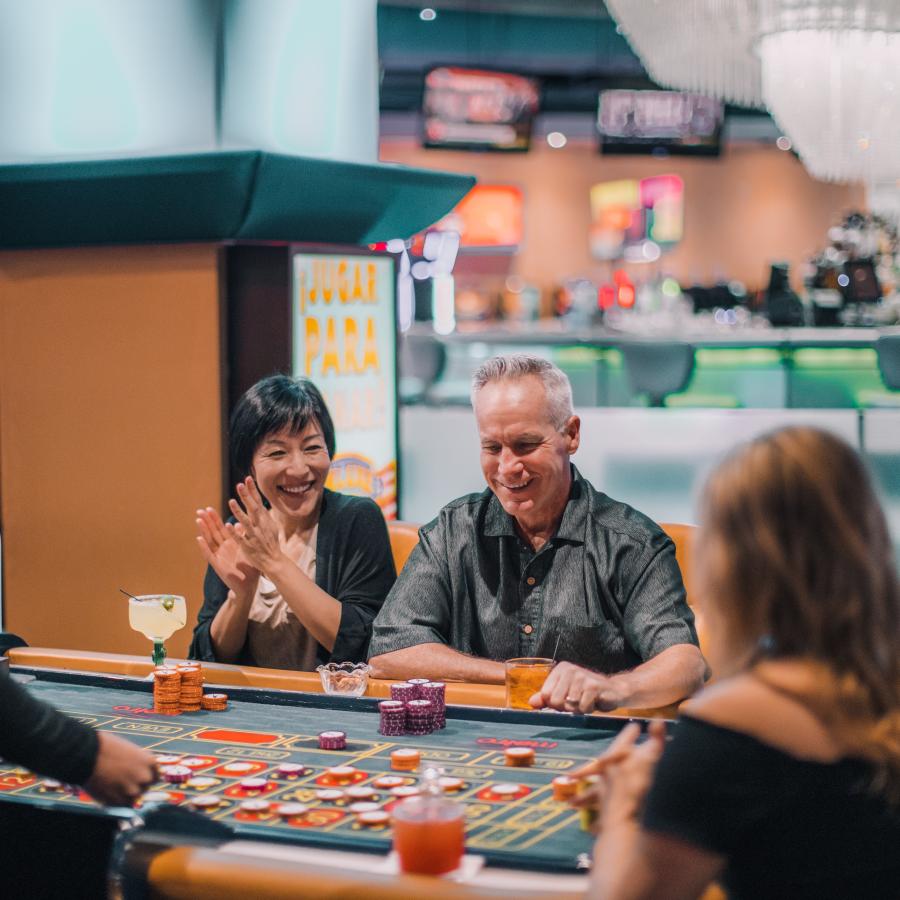 A couple celebrates their win at a casino table