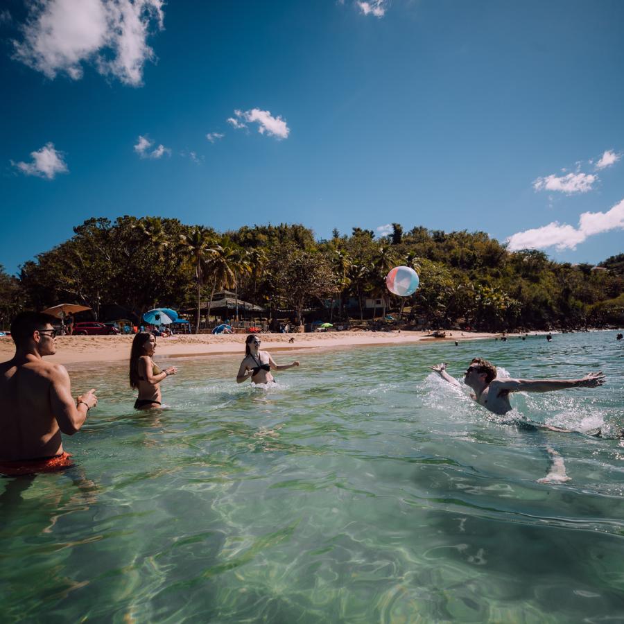 A group of friends plays with a ball at Crash Boat Beach in Aguadilla.