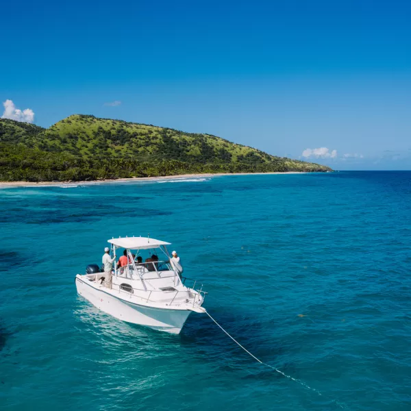 A boat anchored in the calm, clear waters off the coast of Culebra, perfect for snorkeling and island hopping.
