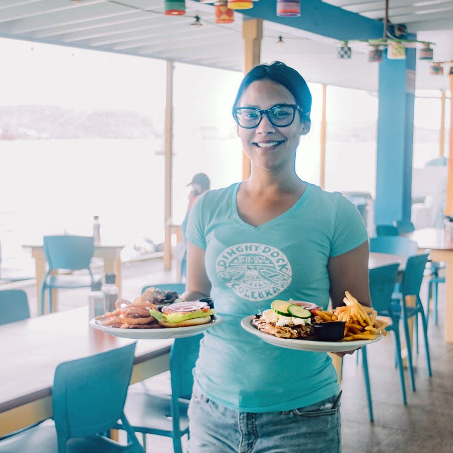 A waiter holds two plates with delicious food in Culebra.