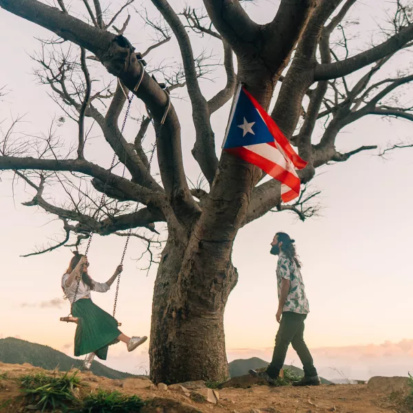 A couple enjoys the outdoors on top of a mountain.