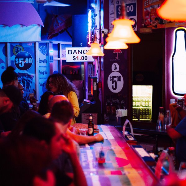 Lively crowd at La Sombrilla Rosa, a popular dive bar in San Juan nightlife.