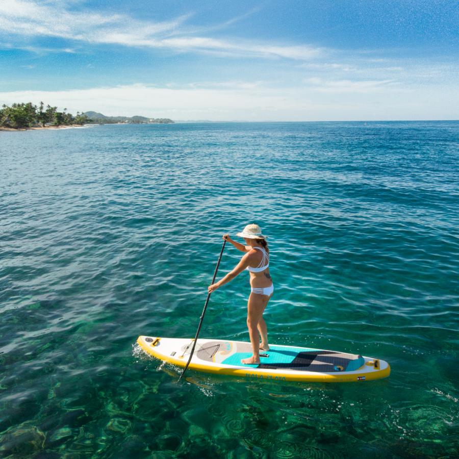 A woman enjoys stand-up paddleboarding in clear waters near Rincon.