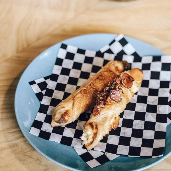 Flaky Puerto Rican pastry filled with sweet cream cheese, known as quesito, on a bakery plate.