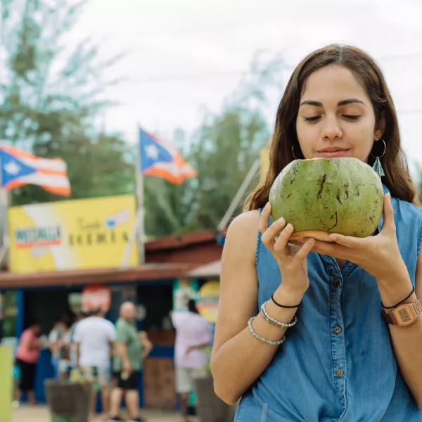Woman sipping fresh coconut water in Piñones, Puerto Rico