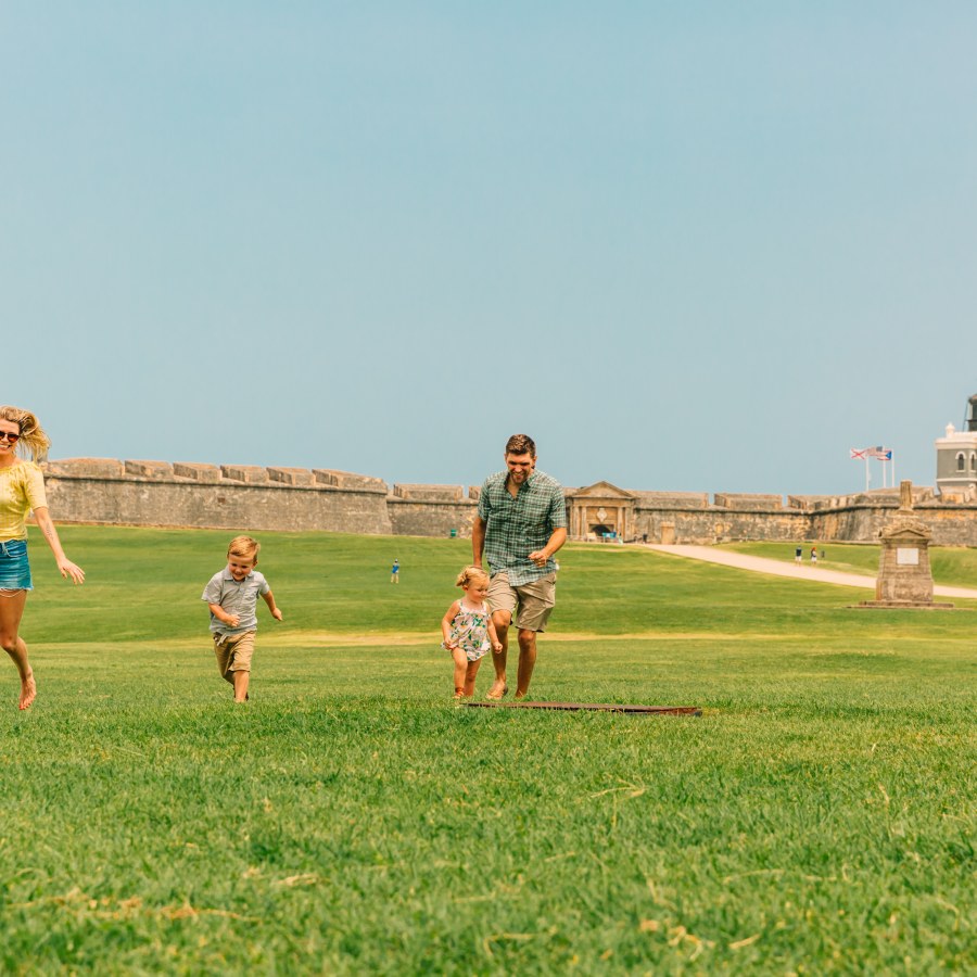 Kids run around the lawn at El Morro