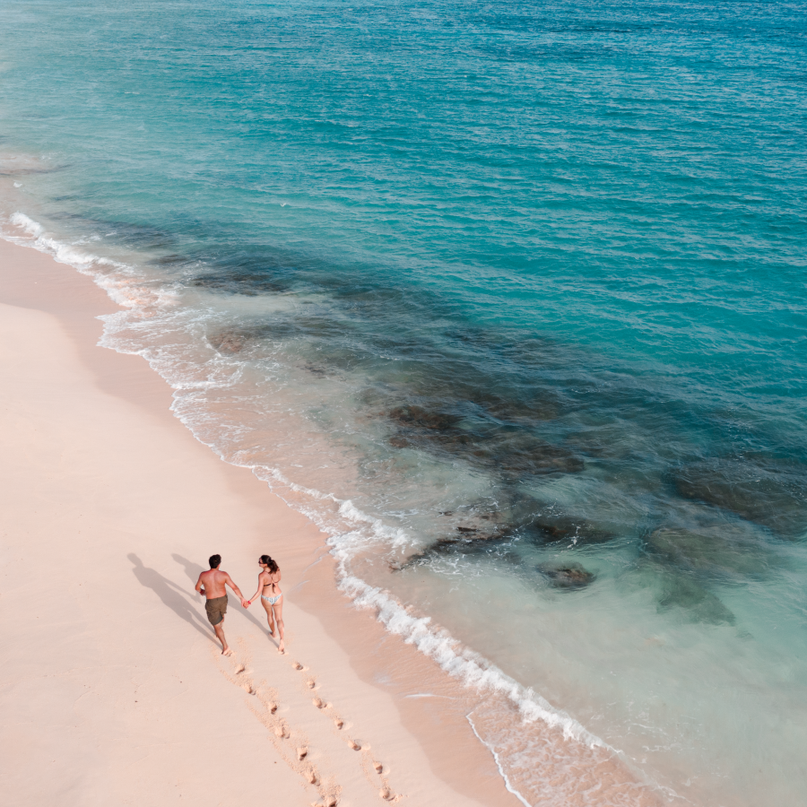 A couple walks along the shore in Isla de Mona 