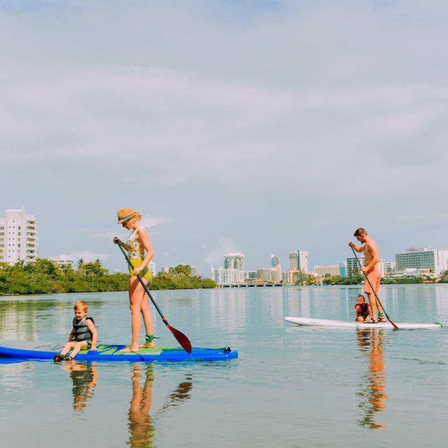 A family paddle boards at the Condado lagoon.