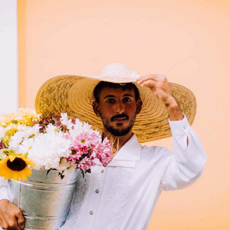Un hombre posa con flores.