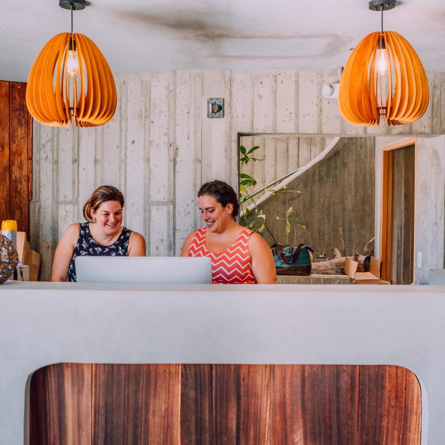 Two front desk agents await for guests at the front desk o El Blok hotel in Vieques.