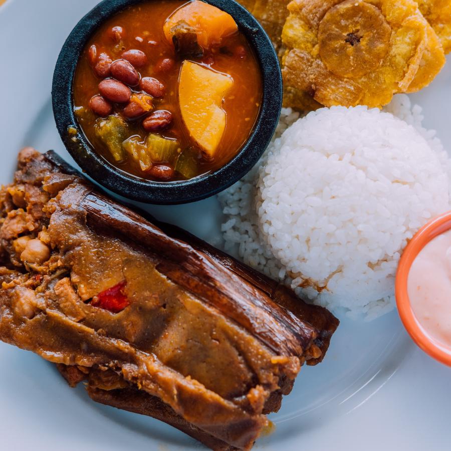 Un plato filtrado de arroz y frijoles tradicionales con pasteles y tostones.