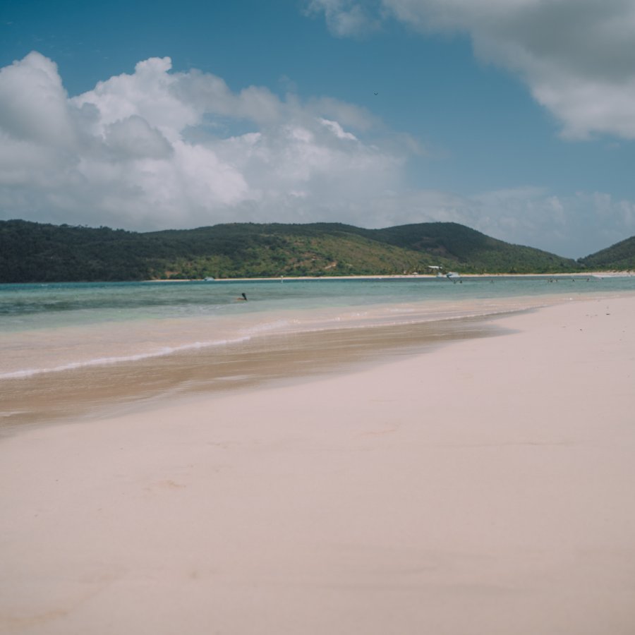 Flamenco beach in Culebra has soft white sand, crystal clear waters, and a backdrop of mountains.