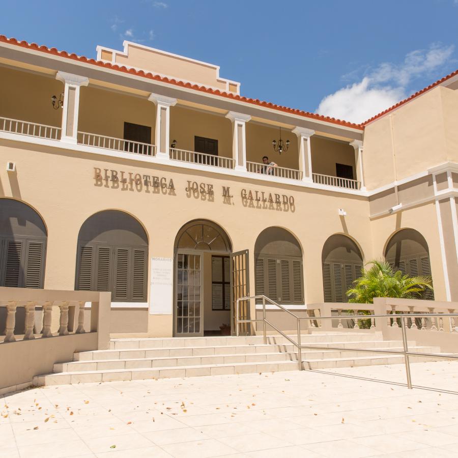 Colonial entrance to the building that houses Juncos' library, the structure is painted in a light tone of yellow. 