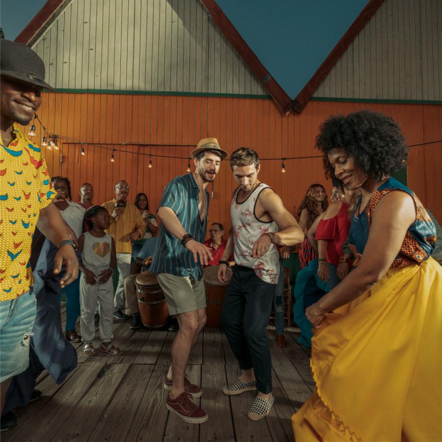 Two men dance with local dancers in Pinones, Puerto Rico