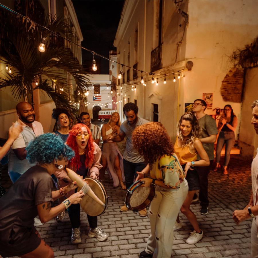 A group of people dance and play music in a street in Old San Juan, Puerto Rico