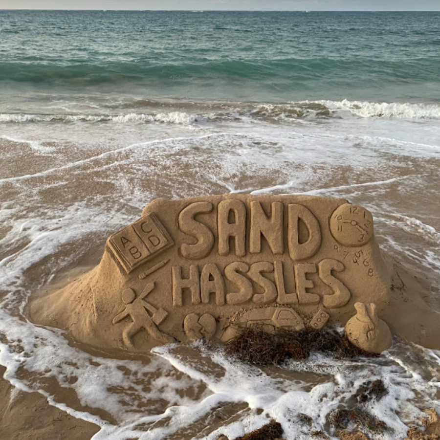 A sand castle spells out "Sand Hassles" on a beach in Puerto Rico
