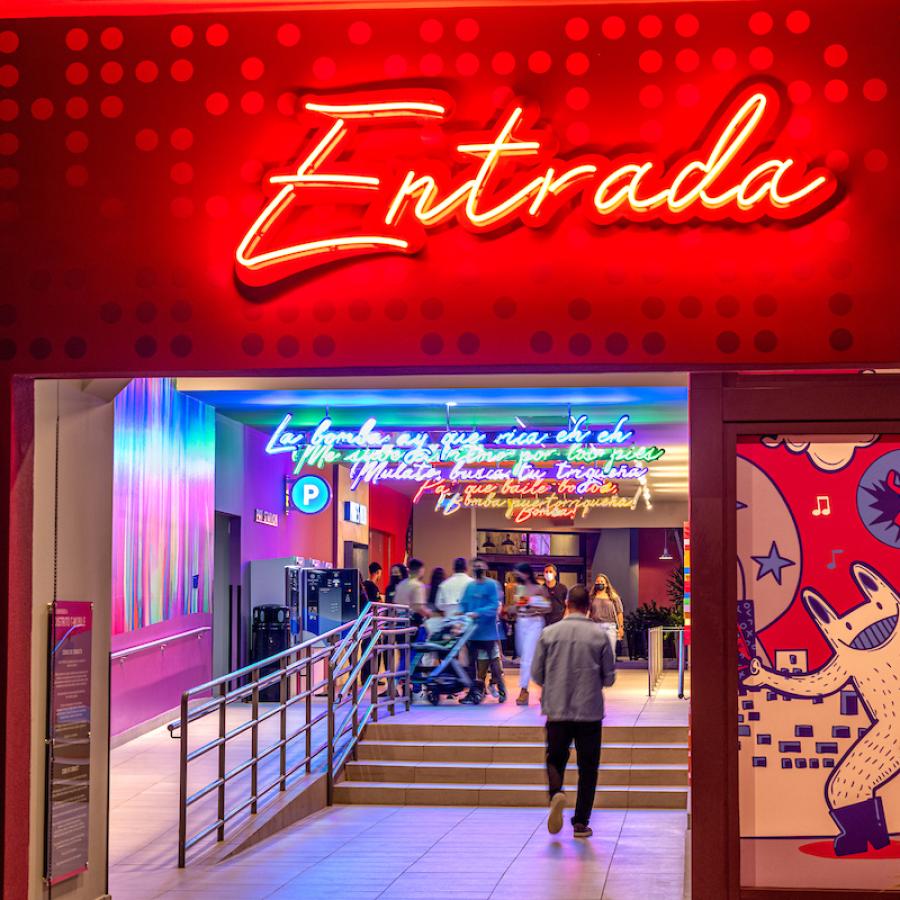 Neon signs in multiple colors light an entrance to Distrito T-Mobile
