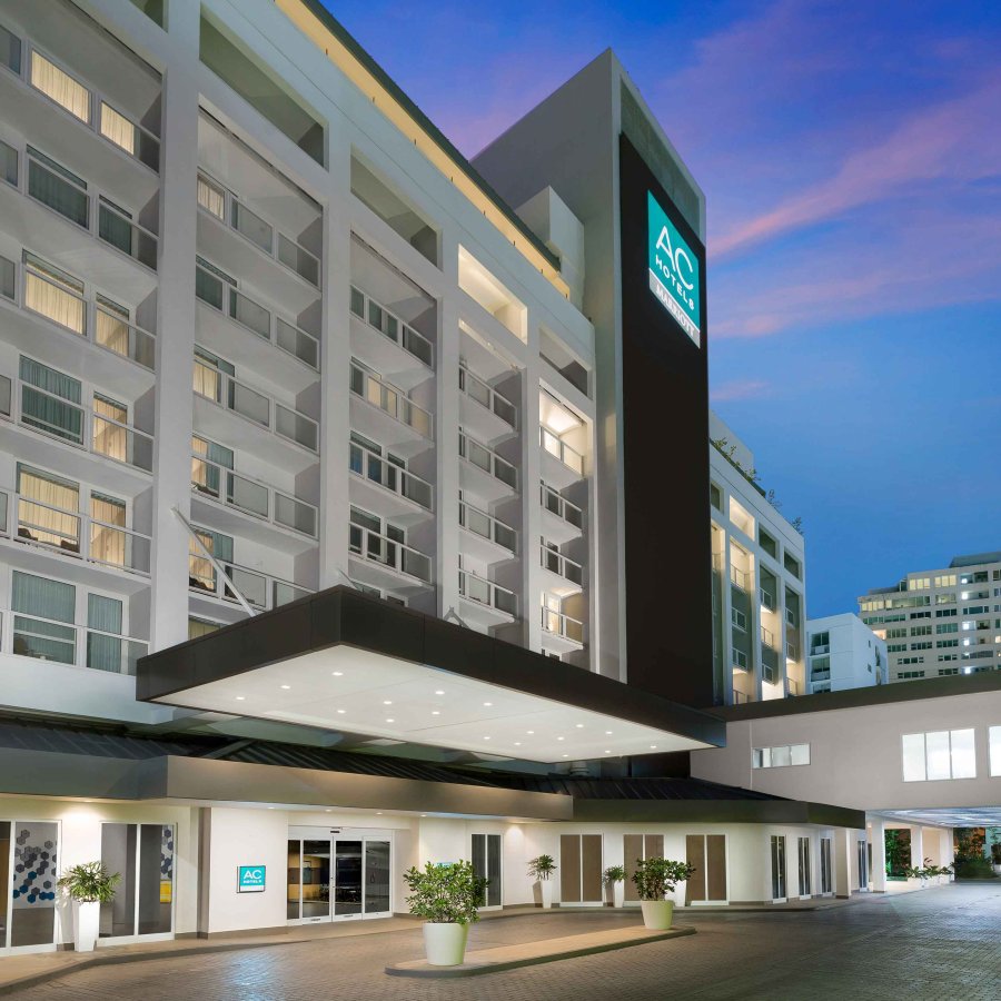 Exterior of AC Hotel by Marriott San Juan Condado, lit up in a colorful evening sky.