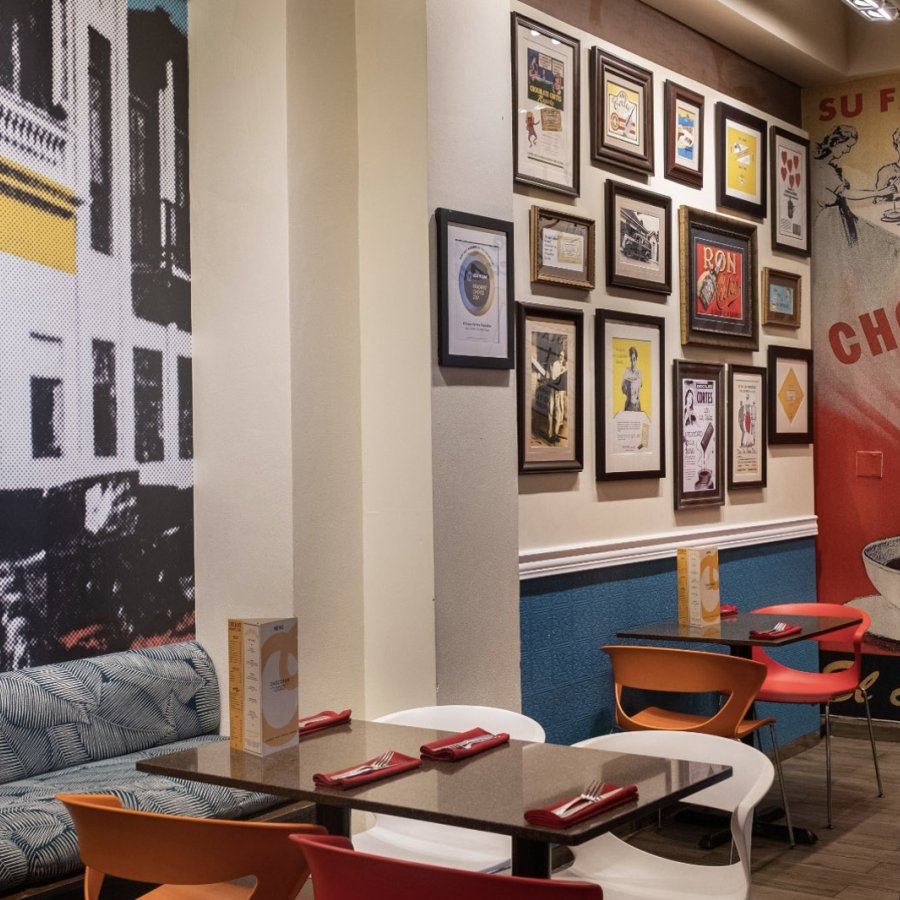 Shot of the colorful interior of Chocobar Cortes in Old San Juan, featuring various wall graphics, tables, and chairs.