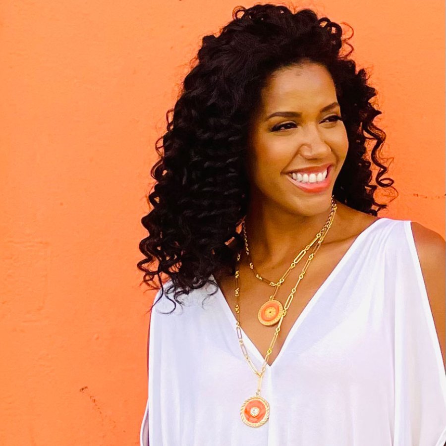 A woman wearing a white top models jewelry by Grace Gonzalez, a Puerto Rican jewelry designer.