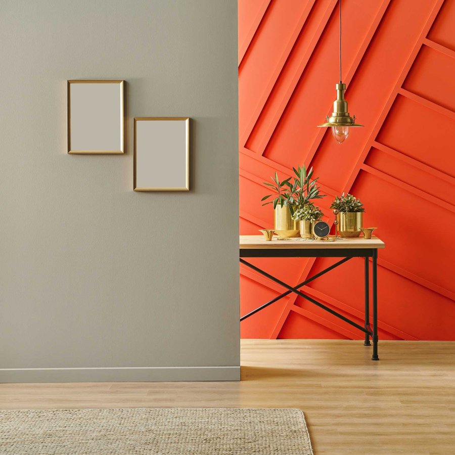 Interior shot of a hallway featuring a medium gray wall with a bright orange wall just behind it.
