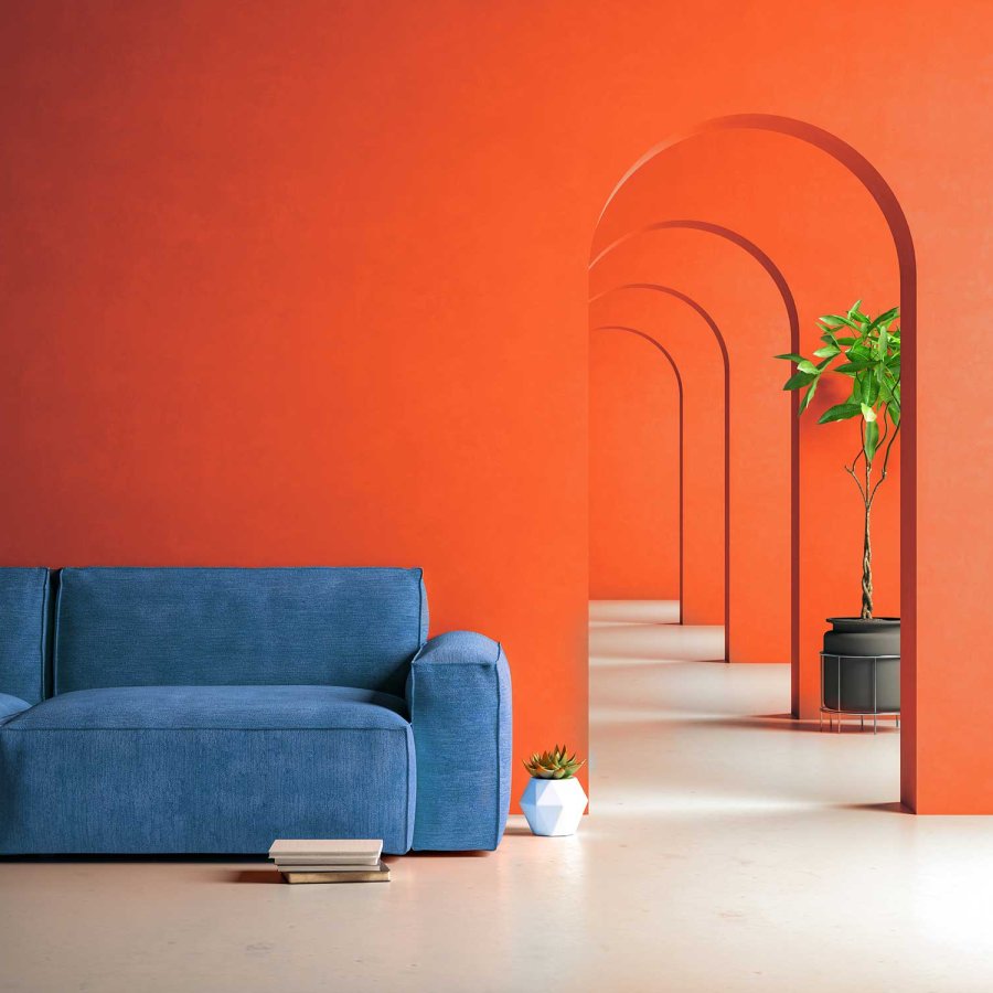 Interior shot of a living room featuring walls painted in Puerto Rico Sunshine, a bright orange shade, with arched doorways and a dark blue couch.