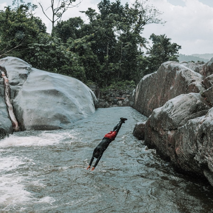 Persona saltando al río.
