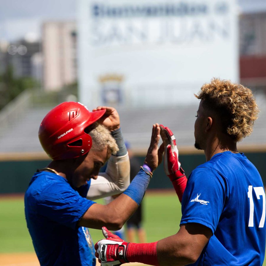 Two baseball players high five after a game in Puerto Rico.