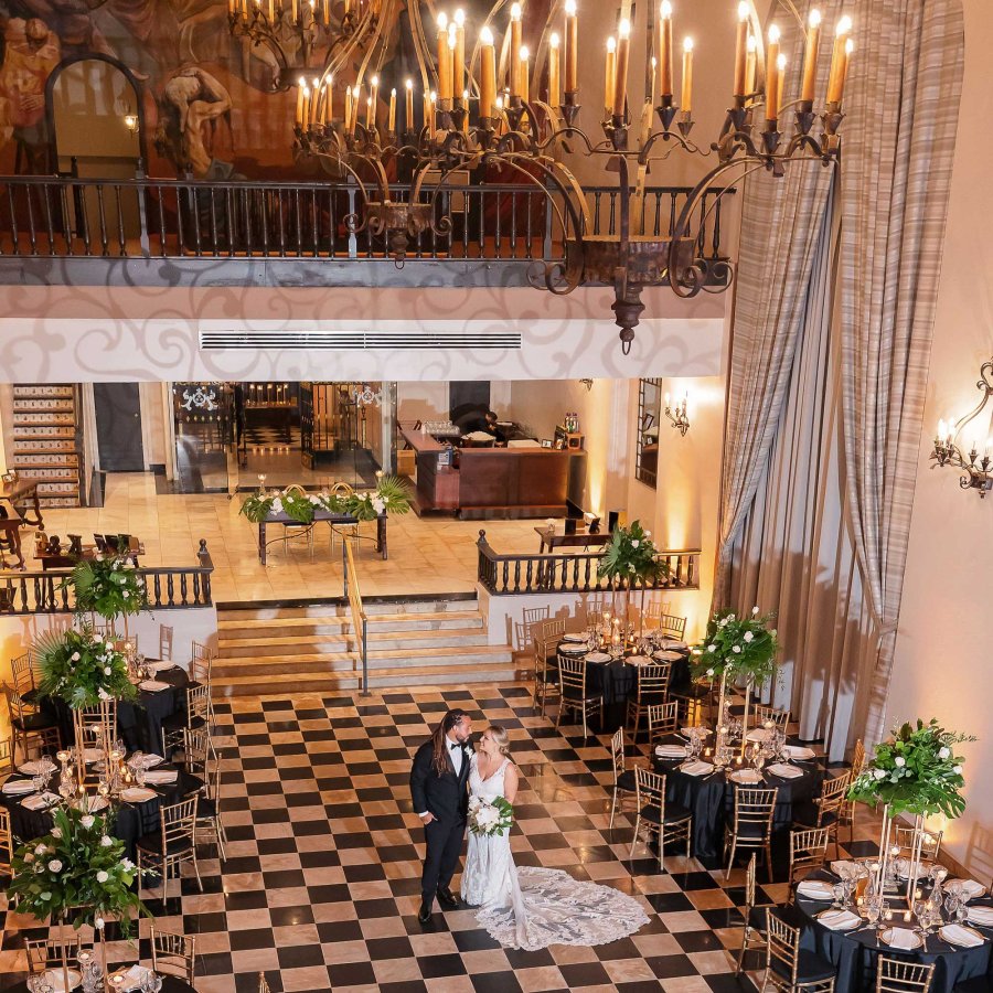 A bride and groom are pictured from above on the black-and-white checkered tile of Hotel El Convento in San Juan, Puerto Rico.