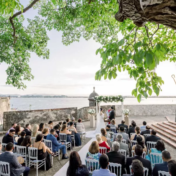 Guests seated for a wedding in front of the iconic La Rogativa statue in Old San Juan.