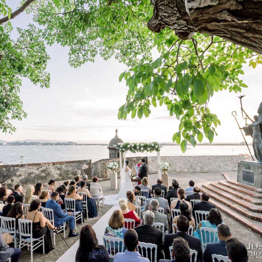 Guests seated for a wedding in front of the iconic La Rogativa statue in Old San Juan.