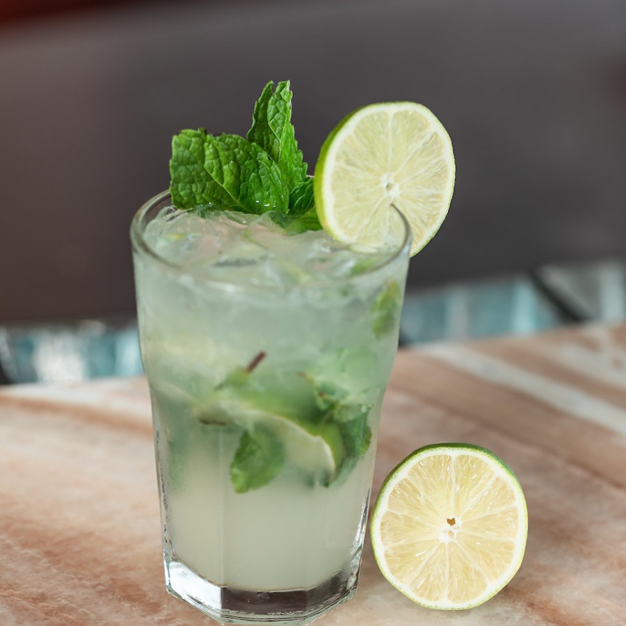 Mojito with a robust amount of mint, topped with a lime.