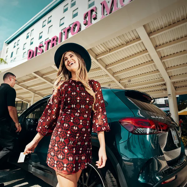 Mujer saliendo de un carro.