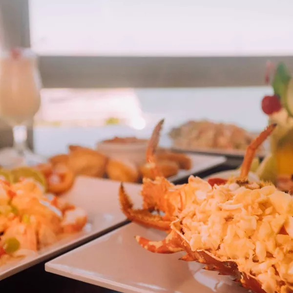 Two plates of fresh lobster sit on a table with a water view at El Dorado restaurant in Salinas, Puerto Rico.