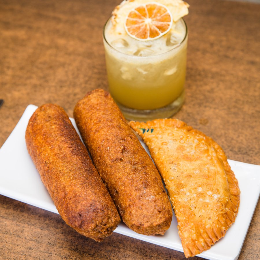 Plate of Puerto Rican fritters with a cocktail.