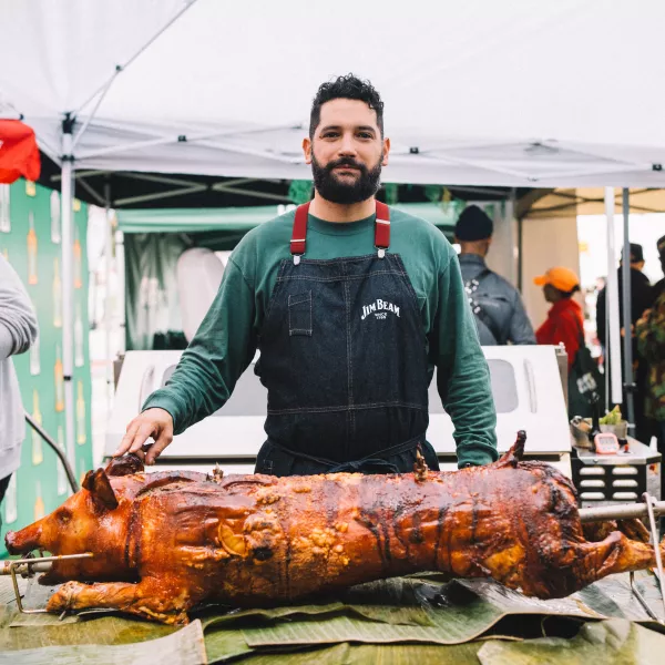 Chef Manolo López asando un lechón.