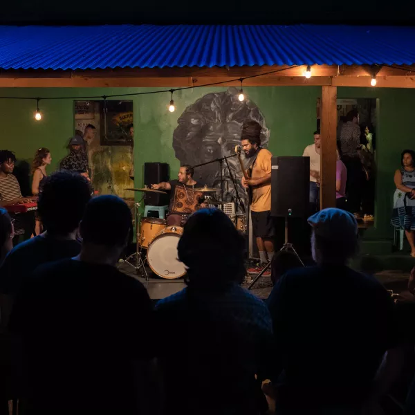 Personas disfrutando un concierto de plena al aire libre.