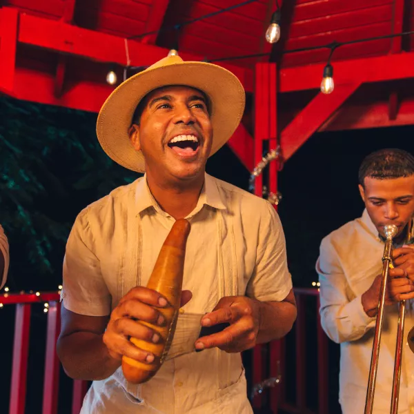 A group of musicians playing the trumpet and güiro, a traditional Puerto Rican instrument.