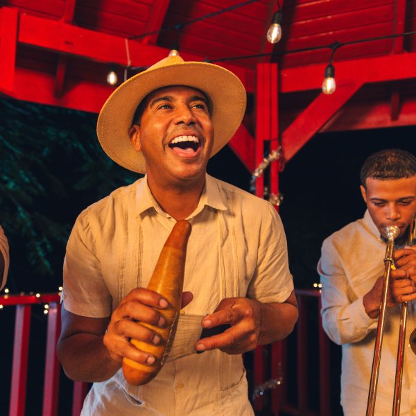 A group of musicians playing the trumpet and güiro, a traditional Puerto Rican instrument.