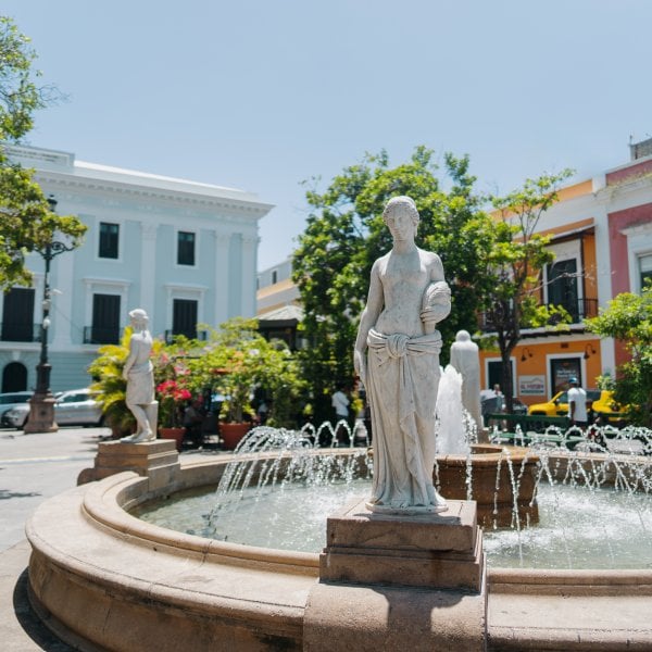 Plaza de Armas in Old San Juan, Puerto Rico, with fountain and surrounding colonial buildings.