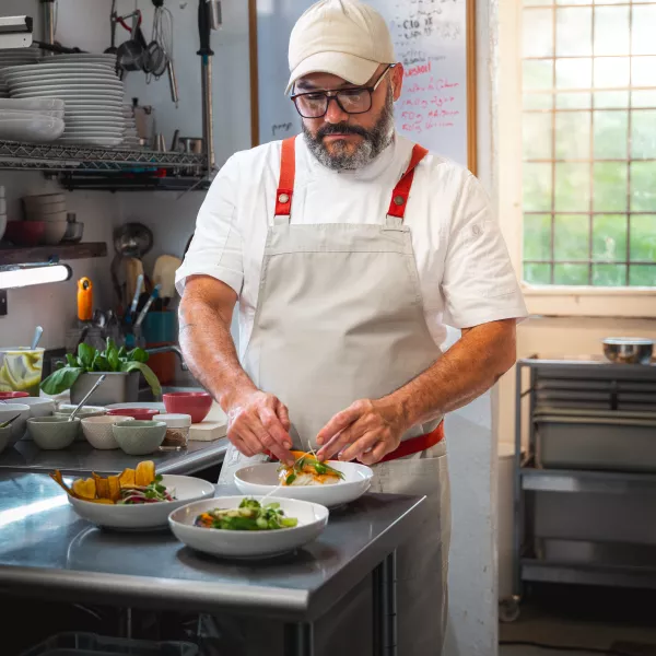 Chef Kevin García, de La Faena Agro Cocina, emplata una creación culinaria en la cocina de su restaurante.