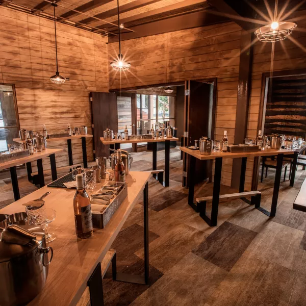 Interior of Ron del Barrilito in Bayamón, Puerto Rico, set up for a mixology experience with bottles, shakers, and cocktail-making tools on wooden tables