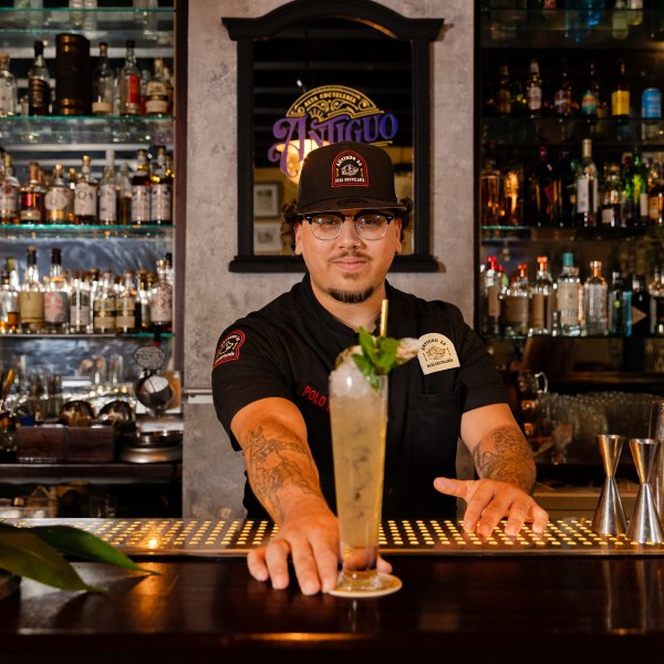Mixologist Giovanni Budet presenting a cocktail at Antiguo 26.
