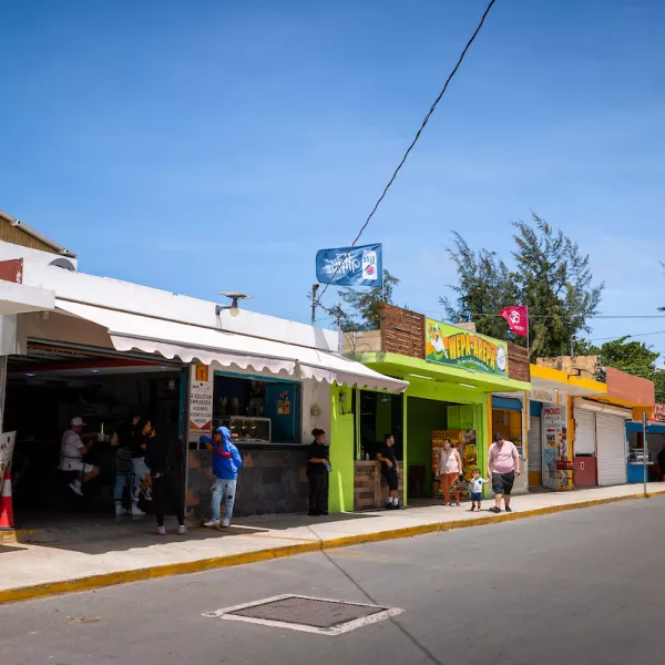 Colorful food kiosks at the Kioskos de Luquillo on Puerto Rico’s east coast, with people visiting local restaurants along the roadside.