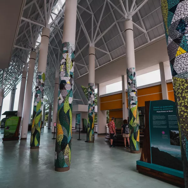 Interior of El Portal Visitor Center with tall columns decorated in colorful mosaic patterns inspired by nature.
