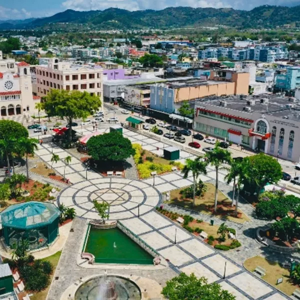 Aerial view of downtown Caguas featuring the central plaza, colorful buildings, and surrounding green mountains in Puerto Rico.