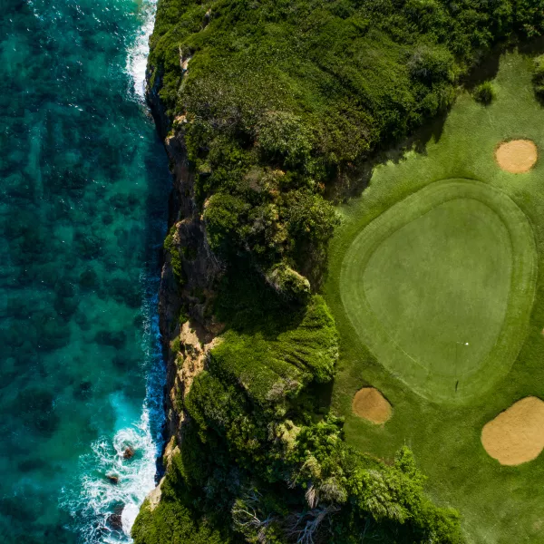 Vista aérea de un green de golf en Royal Isabela, ubicado sobre impresionantes acantilados costeros con vistas al océano Atlántico en Puerto Rico.
