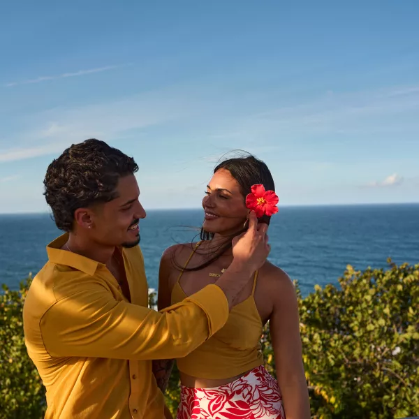 Man putting a flower in a woman's hair.