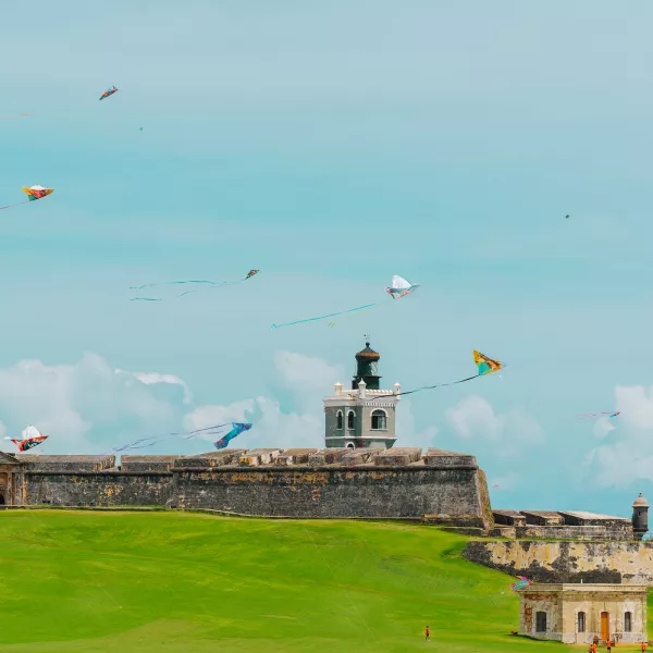 Colorful kites flying over the lawn in front of El Morro, the historic fortress overlooking the Atlantic Ocean in Old San Juan, Puerto Rico.